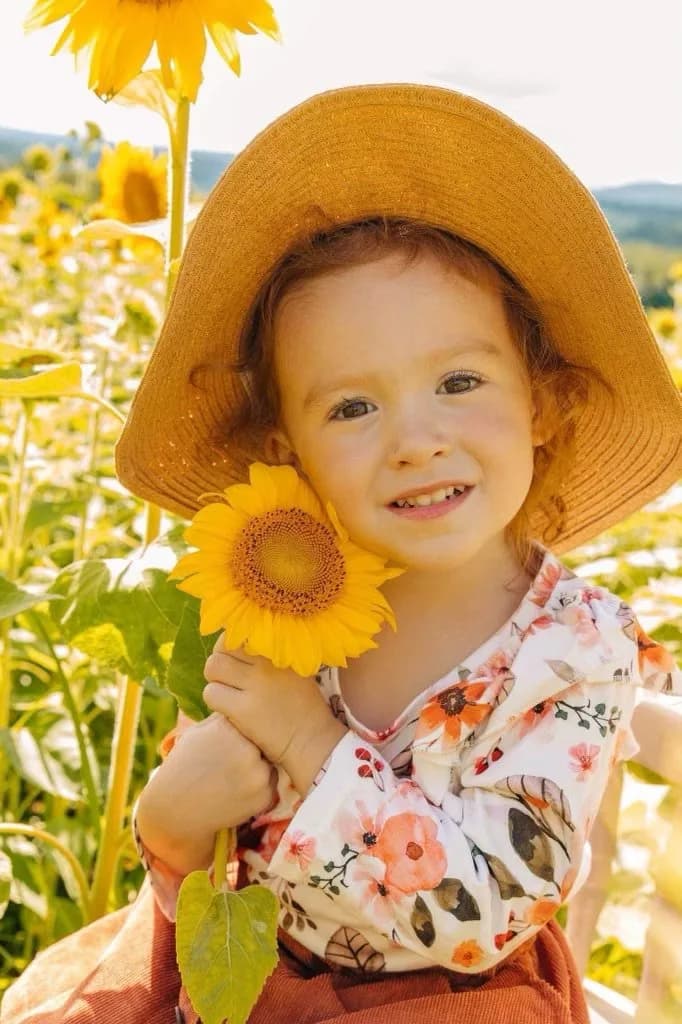 CHAMP beneficiary smiling in a sunflower field